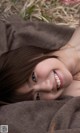 A young woman laying on a blanket in the grass.